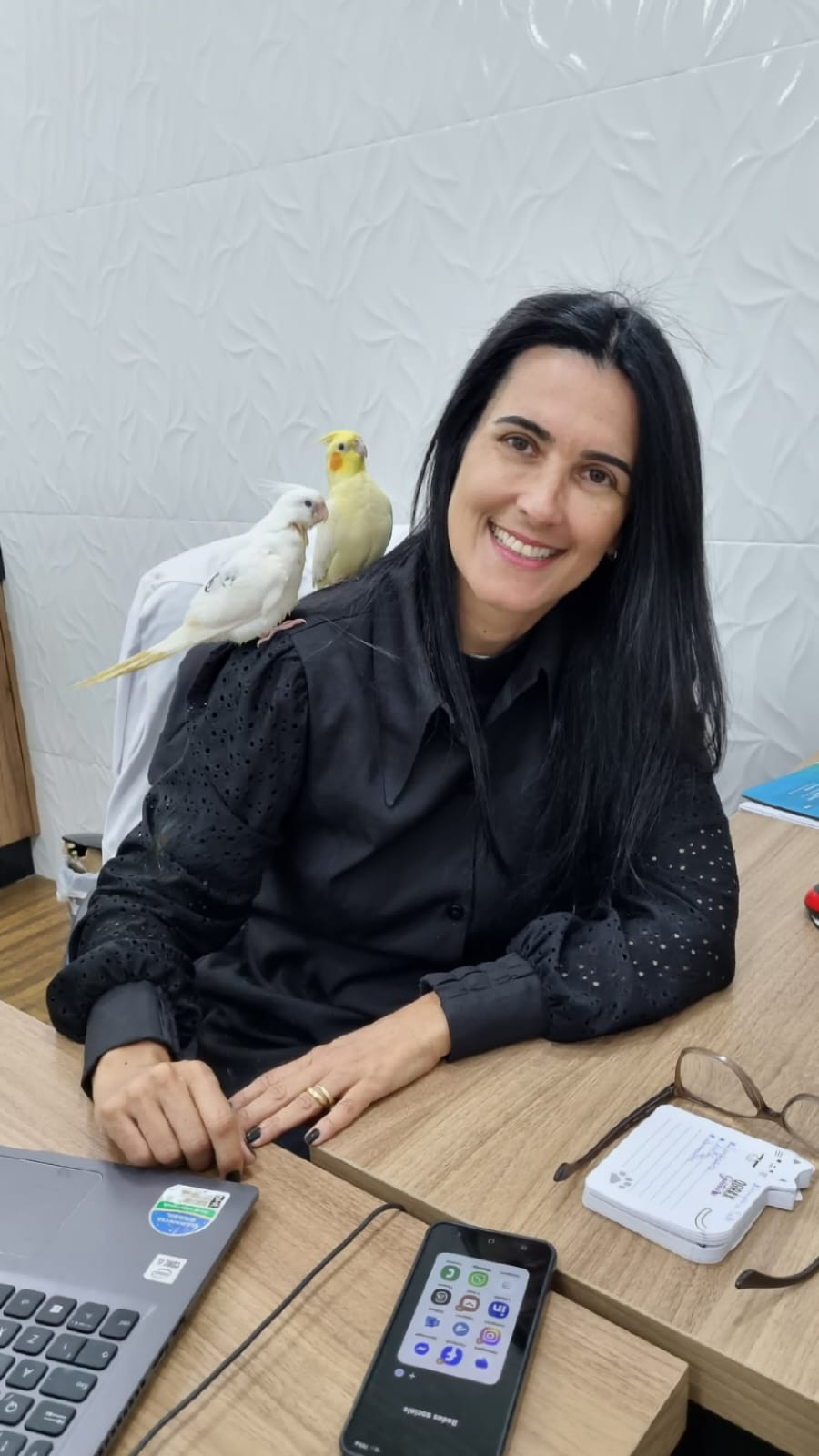 Veterinária atendendo pássaro em consultório em Cuiabá